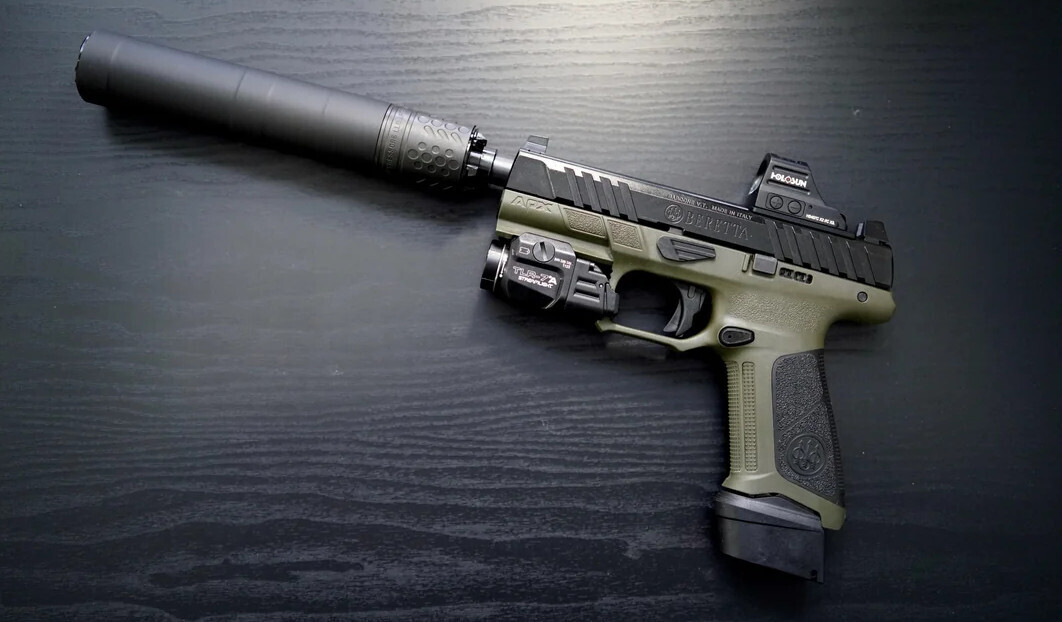 Beretta APX A1 Compact Tactical 9mm pistol equipped with a suppressor, shown in a tactical setup.